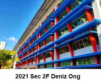 Colorful school building with blue beams, red columns, and rows of windows under a clear sky.